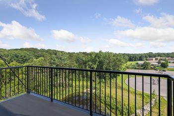 a balcony with a view of a field and trees